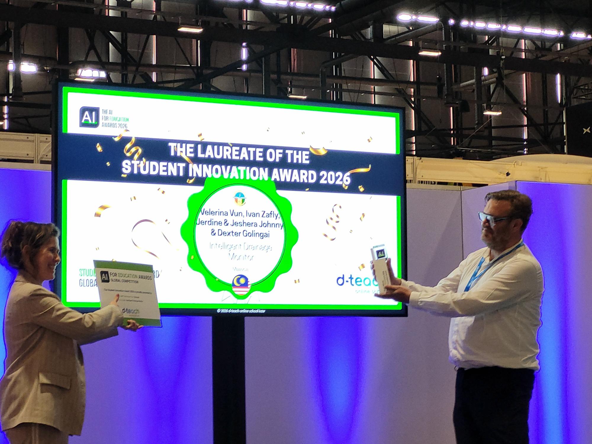 Two participants presenting a certificate and trophy in front of the Student Innovation Award 2026 screen